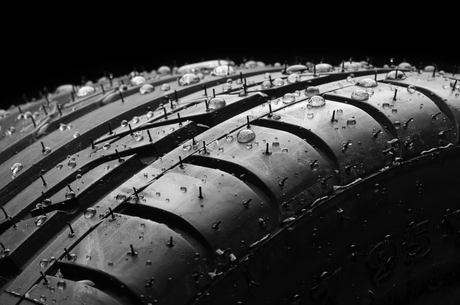 Close up of a new car tire with rain drops sitting on its surface
