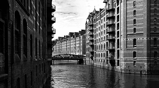 A bridge spans a canal surrounded by tall buildings 