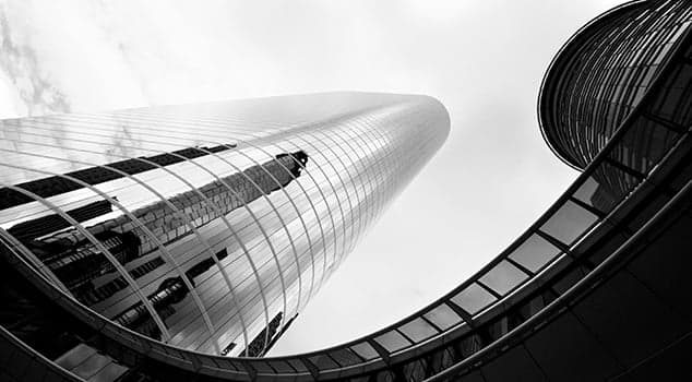 black and white image of houston high rise buildings, looking up from below. 