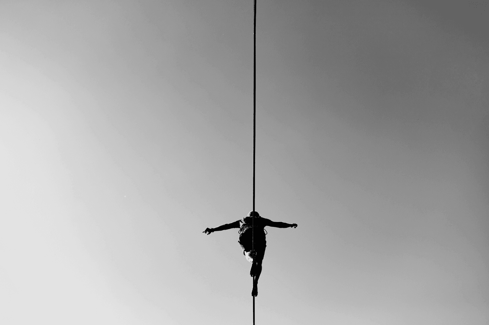 View of man walking a tight rope from below